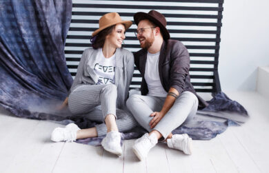 Portrait of a beautiful young happy smiling couple. Modern hipster man and woman in studio with copyspace Portrait of a beautiful young happy smiling couple looking to each other Modern hipster man and woman in studio with copyspace.